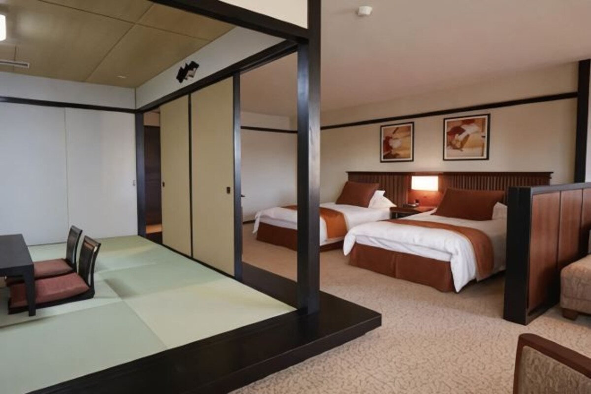 Una habitación de hotel con una cama, un escritorio y una zona de estar.