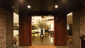 A hotel entrance with a stone facade, a wooden reception desk, and a sign reading 'HOTELDEYAMA HAKONE LAKE SIDE.' - Odakyu Hotel de Yama (Hakone)