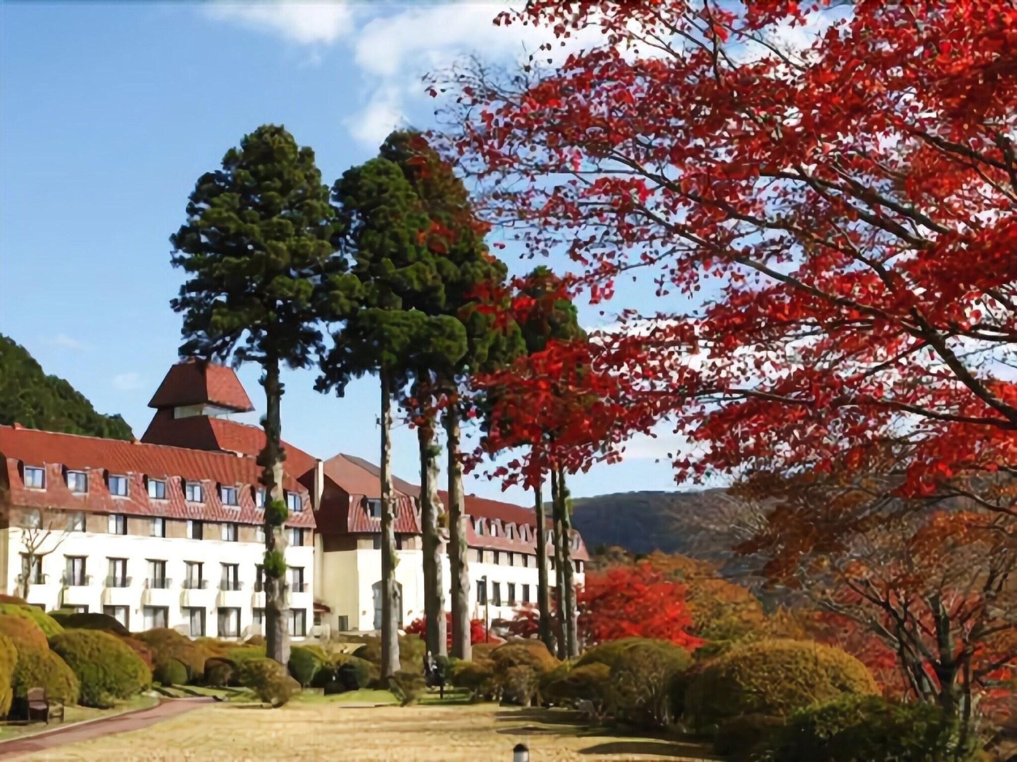 A hotel with a central courtyard, multiple buildings with red roofs, and surrounding trees.