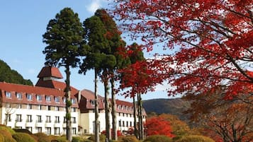 A hotel with a central courtyard, multiple buildings with red roofs, and surrounding trees.