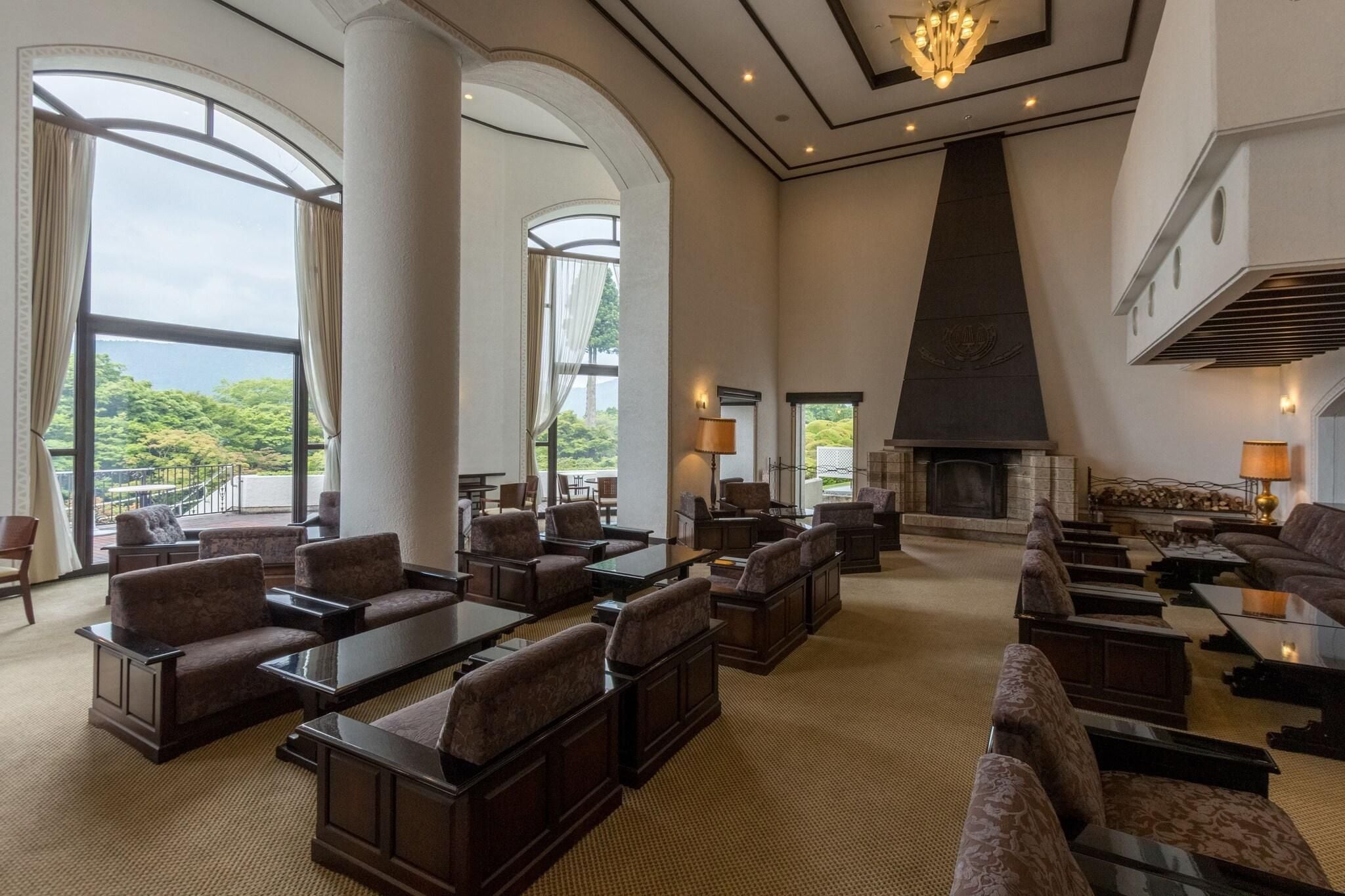 A spacious lobby with high ceilings, large windows, and a fireplace.