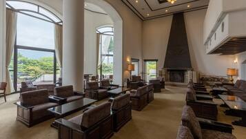 A spacious lobby with high ceilings, large windows, and a fireplace.