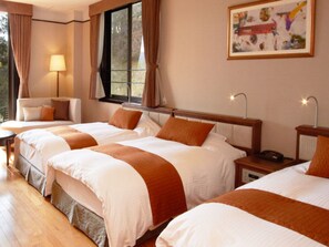 A hotel room with three beds, a sofa, a lamp, and a painting on the wall.