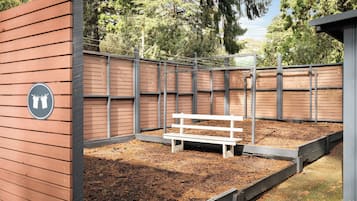 A fenced outdoor area with a bench and a sign indicating a restroom.