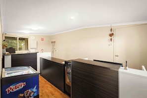 A modern kitchen with a refrigerator, a coffee machine, and a microwave.