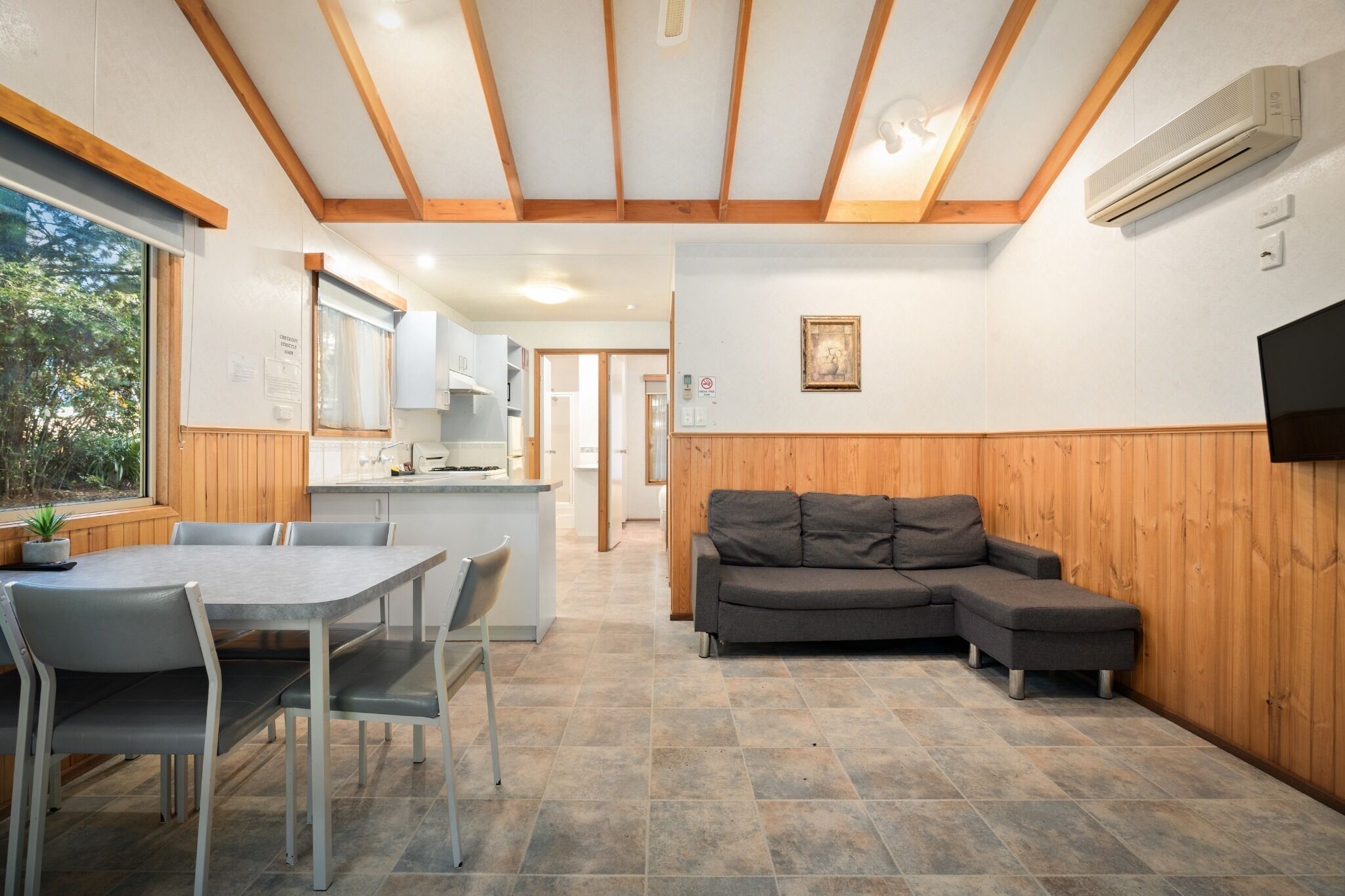 A modern interior with a dining area, a sofa, and a kitchen.