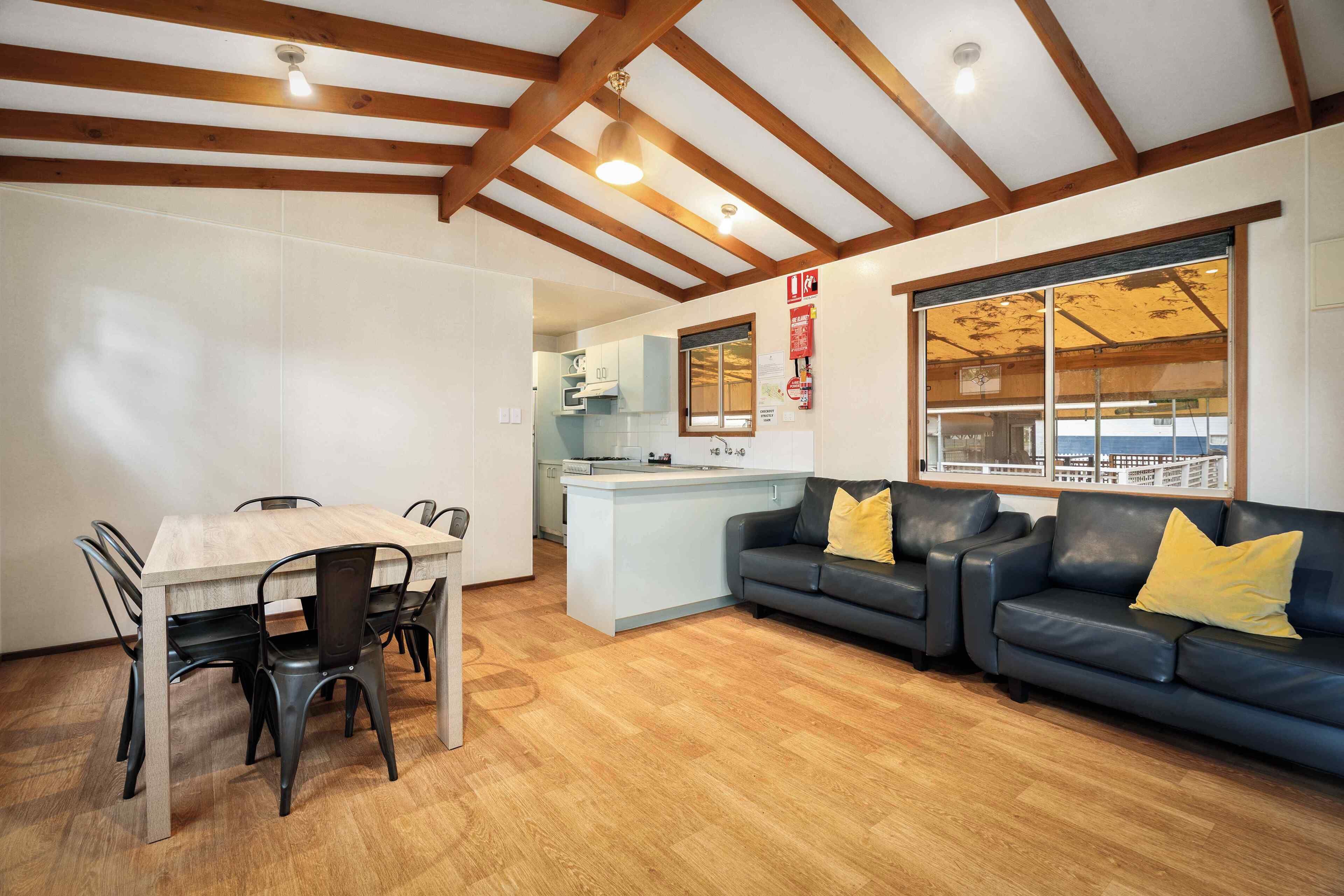 A modern interior with a dining area, a sofa, and a kitchen.