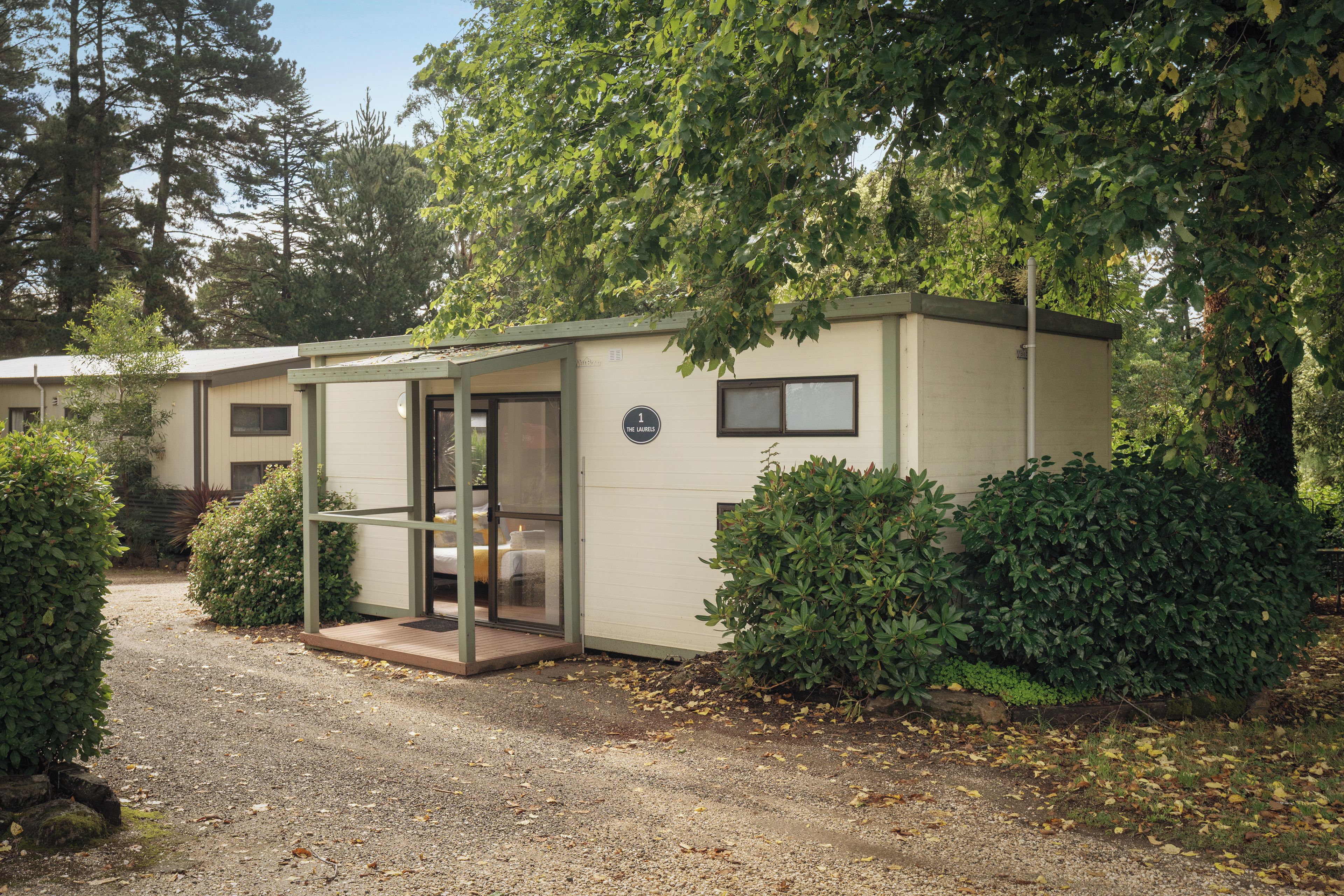 A single-story mobile home with a covered porch, a small window, and a door.