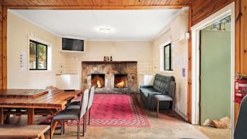 A cozy room with a stone fireplace, seating, and a television.