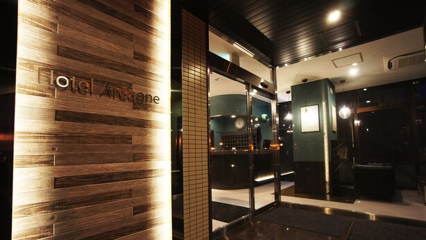 A hotel reception area with a wooden wall and a glass door leading inside. - Hotel AreaOne NOBEOKA (Nobeoka)