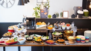 A buffet table with various dishes and a coffee machine. - Hotel AreaOne NOBEOKA (Nobeoka)
