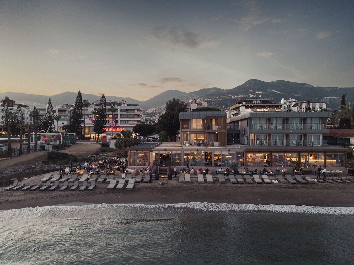 A coastal hotel with outdoor seating and a view of the sea.