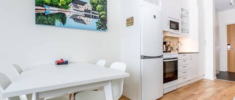 Una cocina moderna con armarios blancos, microondas y cafetera.