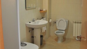 Un baño pequeño con lavamanos, inodoro y espejo.