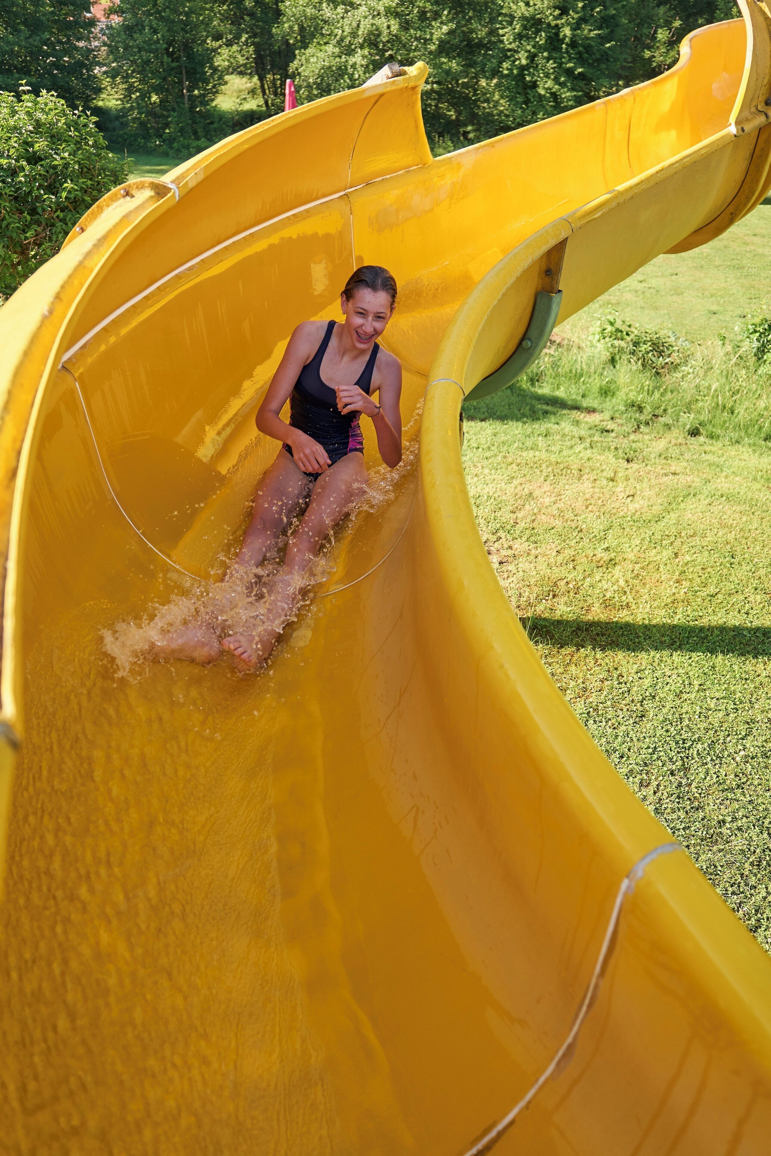 A person sliding down a yellow slide.
