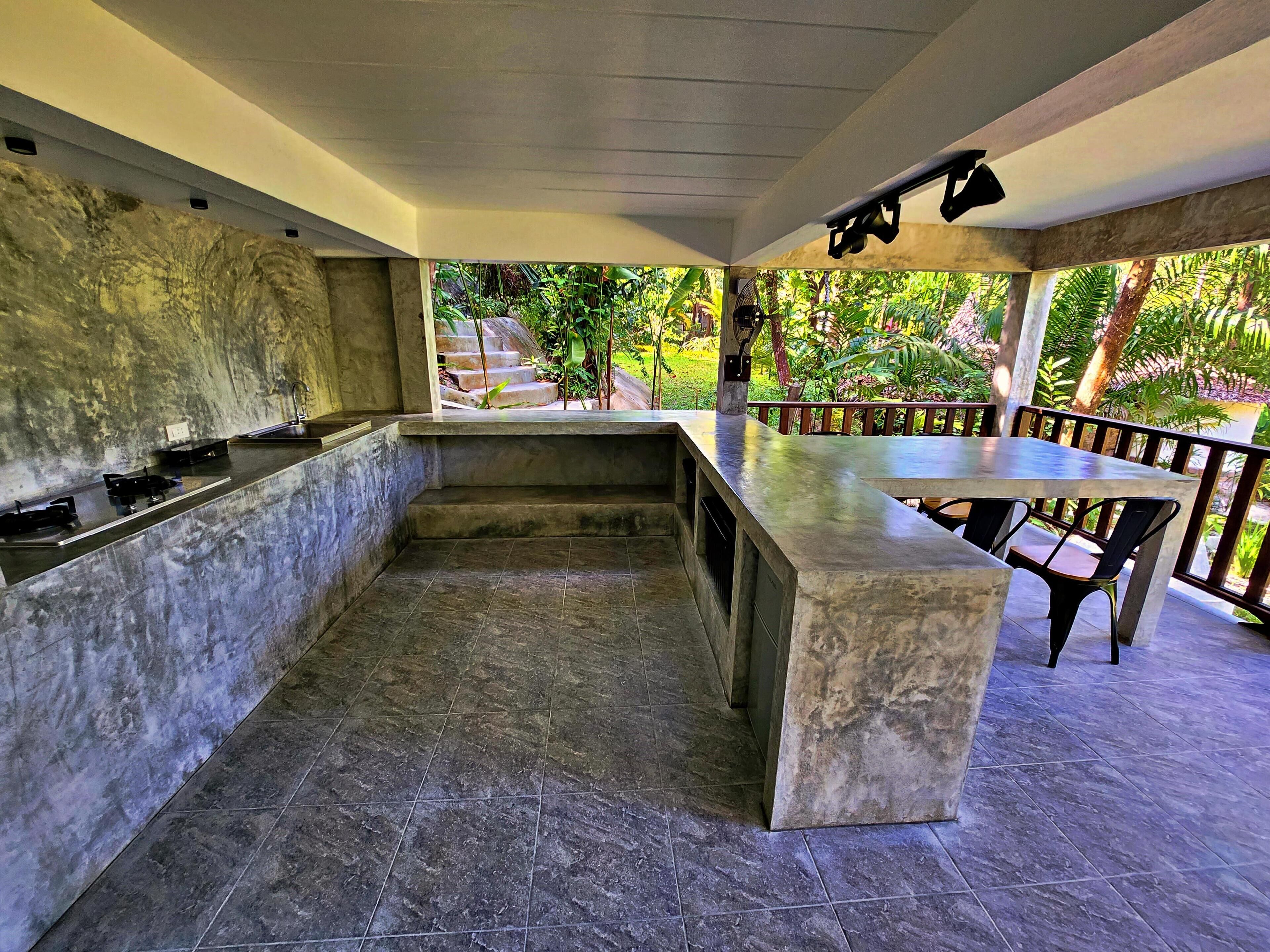 A kitchen with a marble countertop and a dining area with a table and chairs.