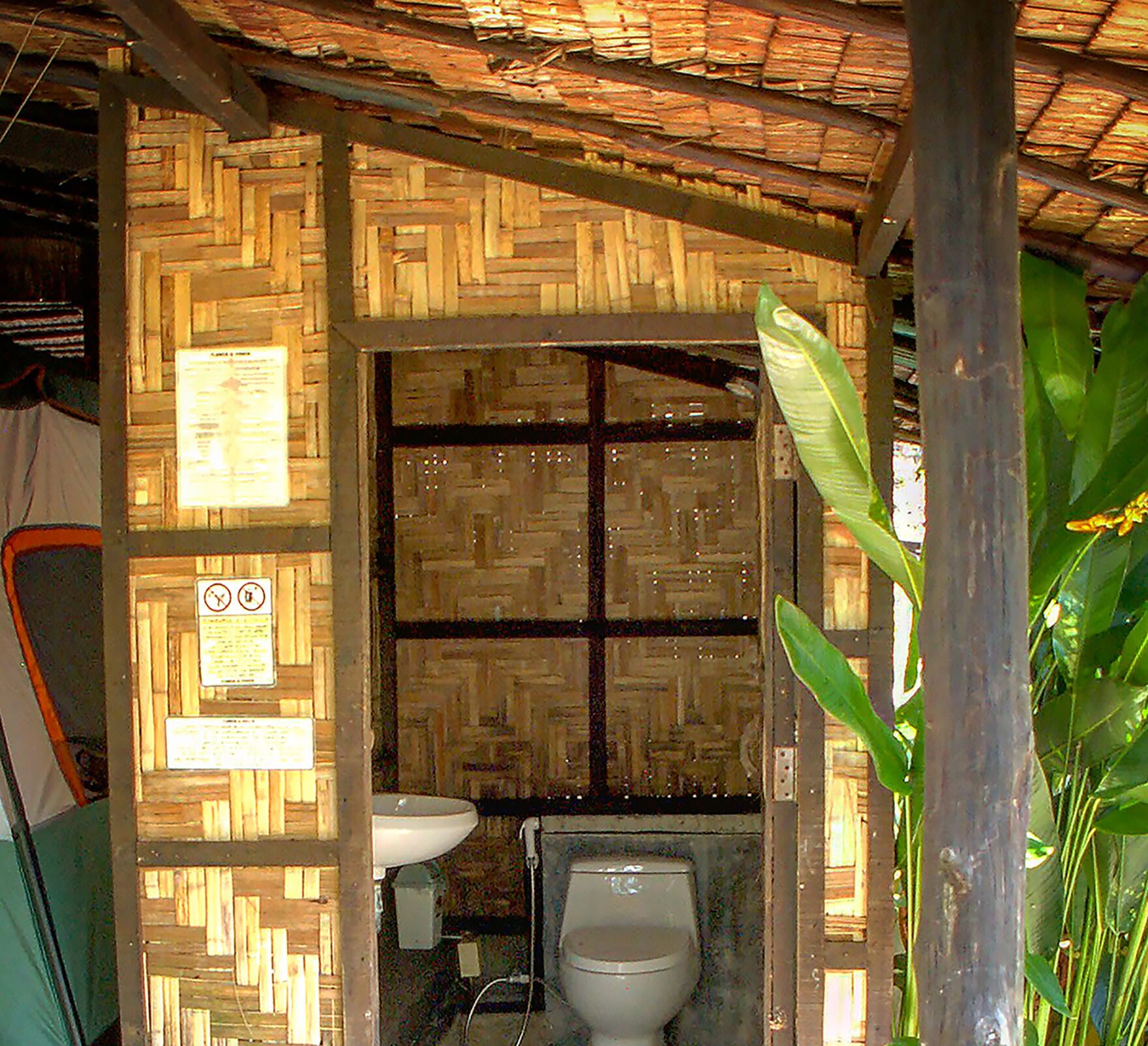 Un baño pequeño y rústico con pared de madera y un inodoro.