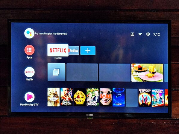A television screen displaying a media streaming interface with various apps and movie thumbnails. - Flower Power Village (Ranong)