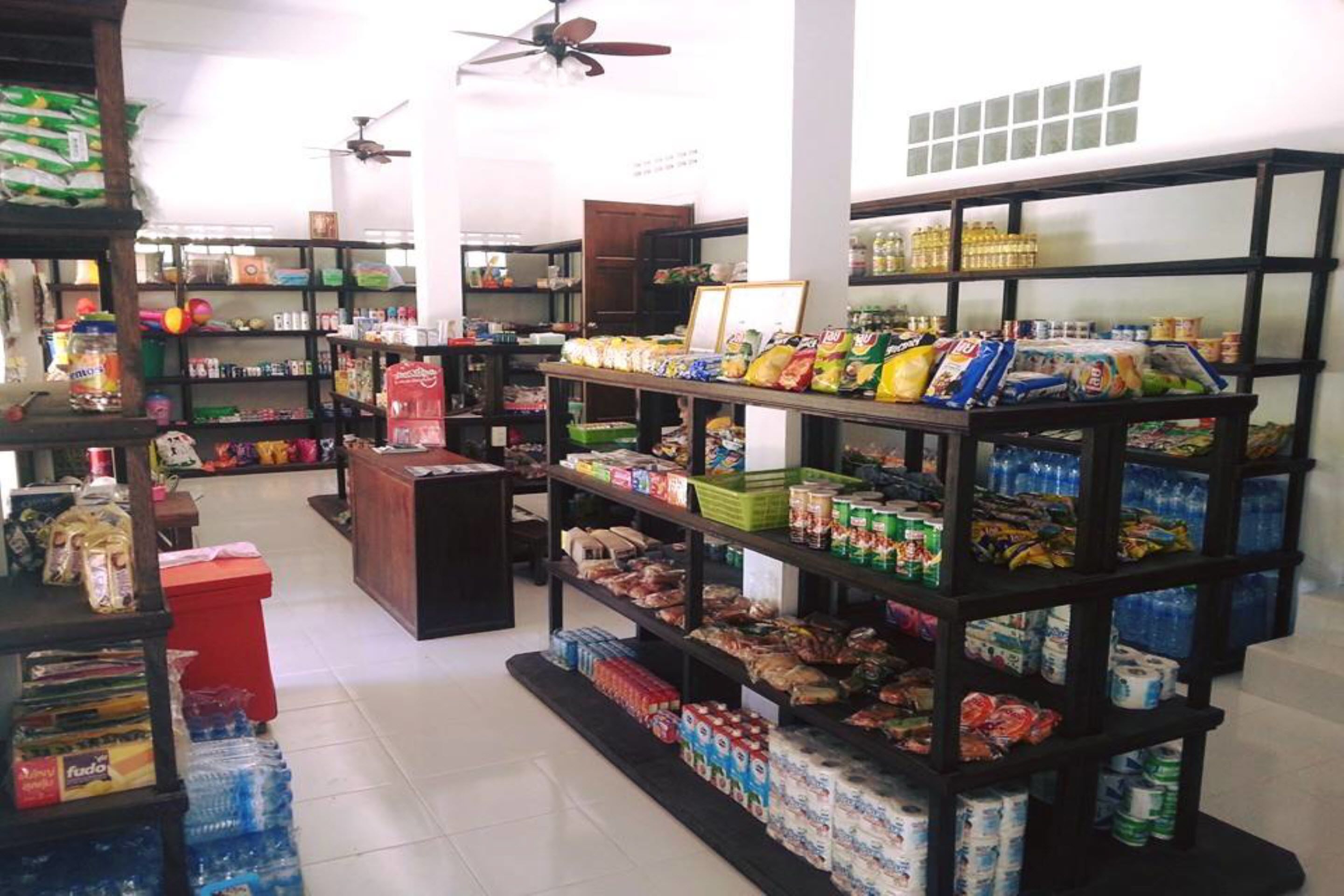 A grocery store with shelves stocked with snacks, beverages, and household items.