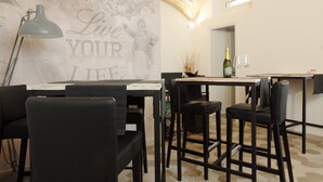 Un comedor moderno con barra, sillas de cuero negro y una pared con el lema 'Live Your Life'.