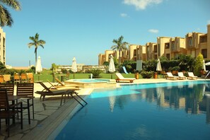 Piscine extérieure, parasols de plage, chaises longues