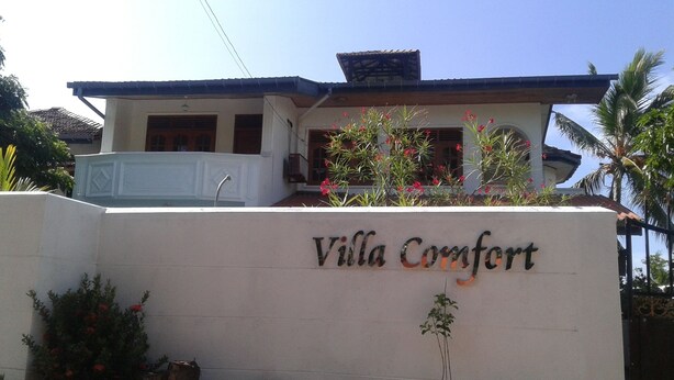 A sign for Villa Comfort with a white wall and a roofline. - Villa Comfort (Hikkaduwa)