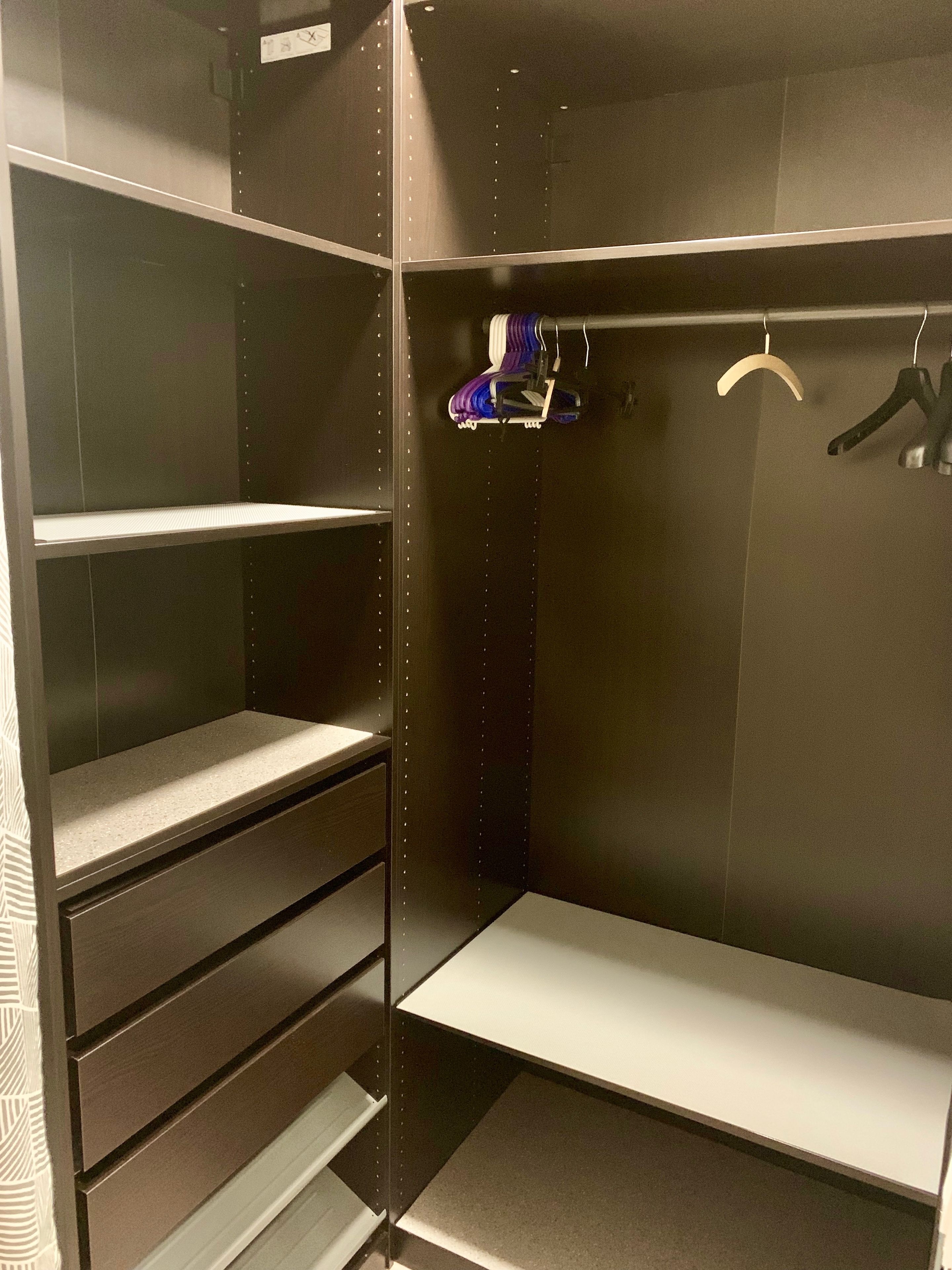 A walk-in closet with open shelving, a hanging rod, and a shoe rack.