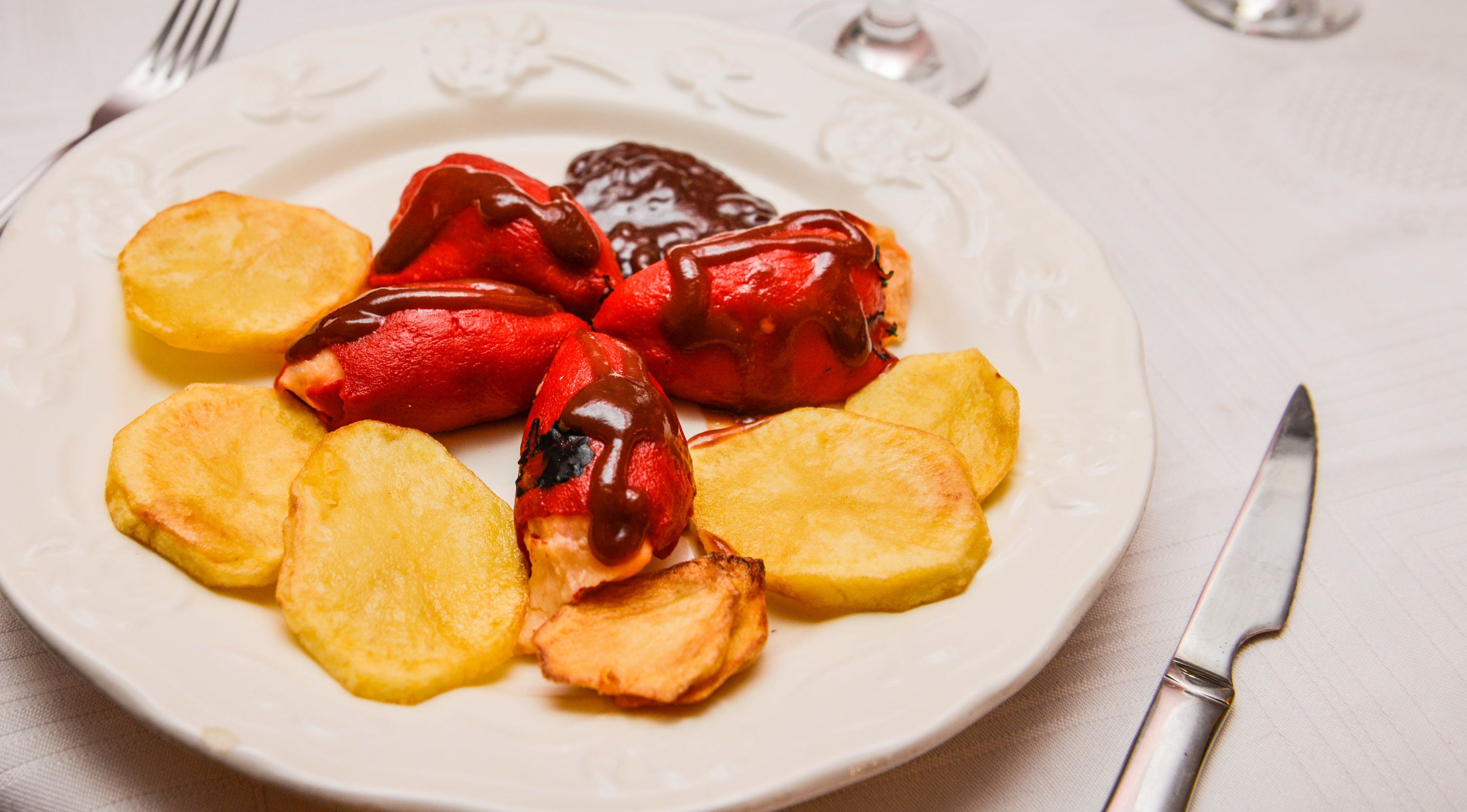 Un plato con pimientos rojos y patatas fritas.