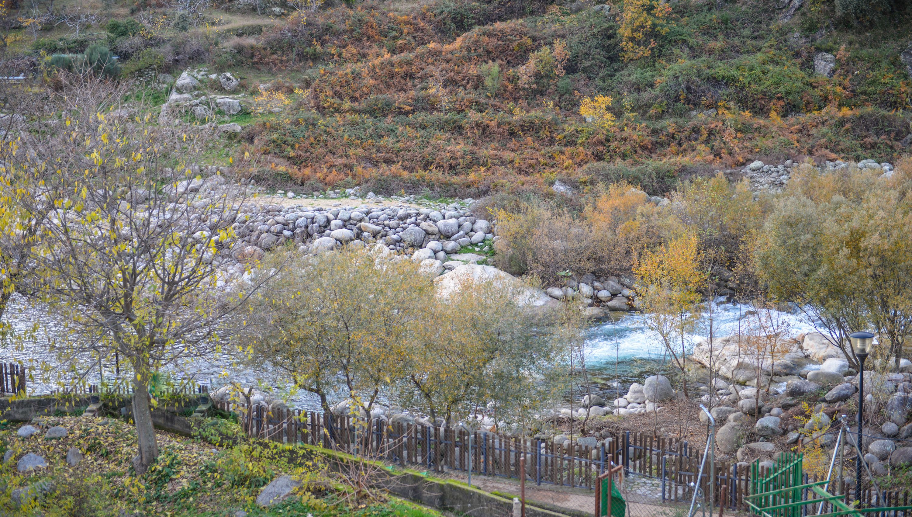 Un río serpentea a través de un paisaje rocoso con follaje otoñal.