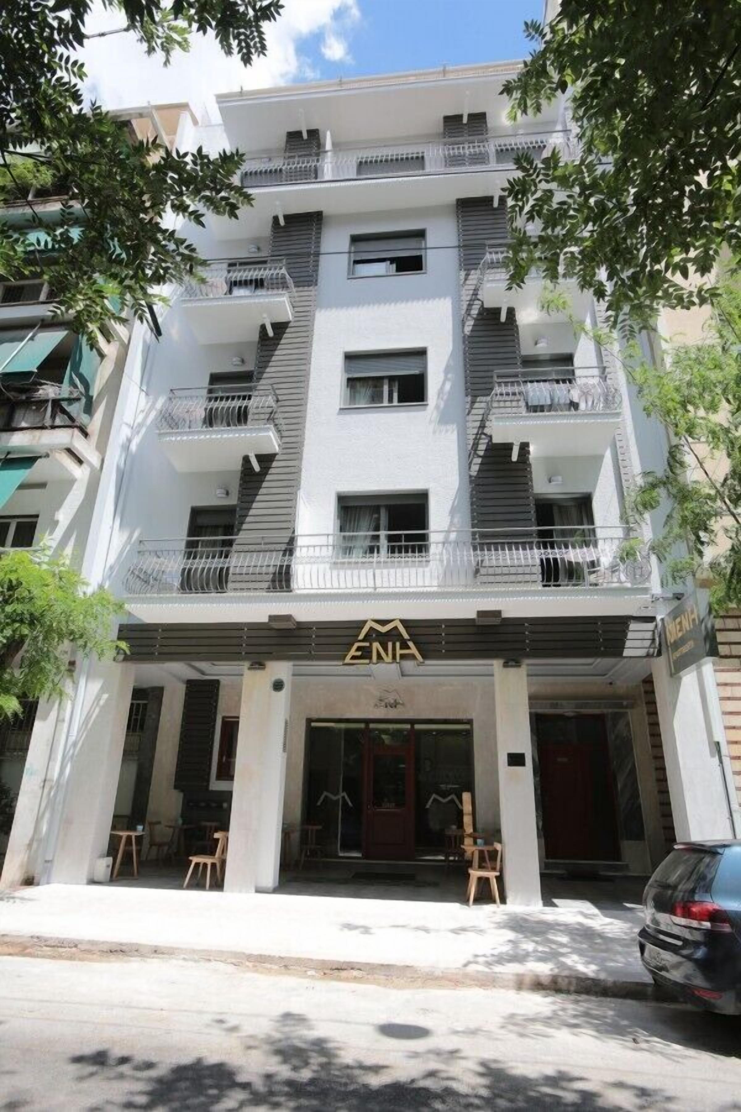 Un immeuble à plusieurs étages doté de balcons, avec une entrée au niveau du sol et une enseigne de restaurant bien visible.