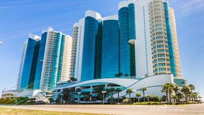 Um hotel moderno com vários edifícios altos, destacando uma estrutura curva proeminente na base.