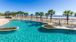 A clear blue swimming pool with palm trees and a beach in the background. - Turquoise Place 2806C (Orange Beach)