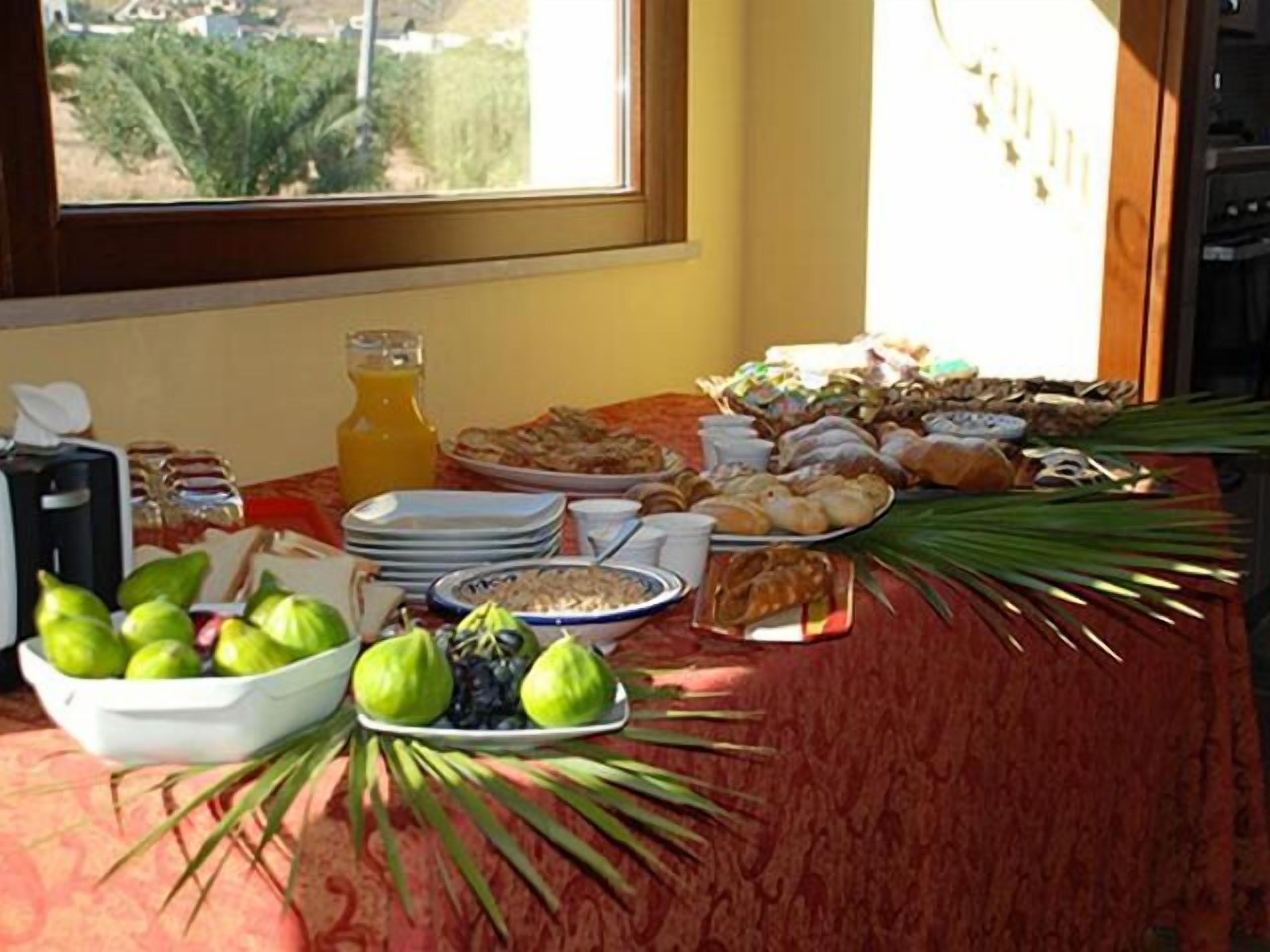 A breakfast buffet with various dishes and a window view.