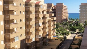 A multi-story residential building with balconies, a parking area, and a view of the sea. - Apartamentos Marina D'Or 3000 (Oropesa del Mar)