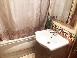 Ein Badezimmer mit Badewanne, Waschbecken und Spiegel.