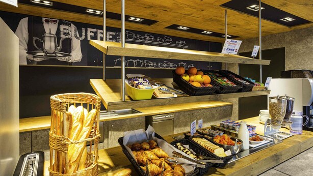 Un bufé de desayuno con pan, bollería, frutas y bebidas.