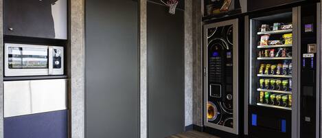A vending machine area with a basketball hoop and a sign for "School Service".