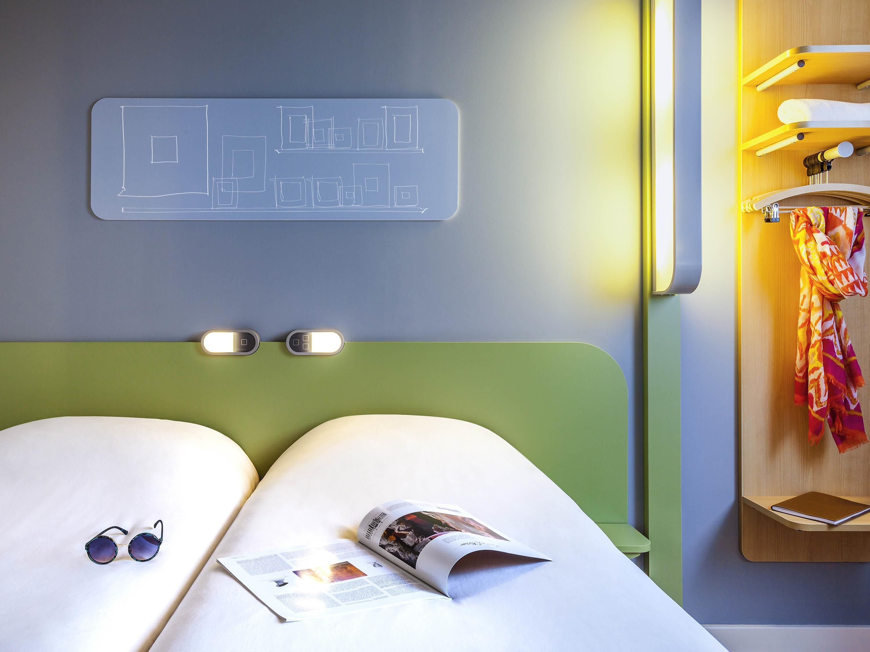Ein Hotelzimmer mit einem Bett, einer Zeitschrift und einer Sonnenbrille.