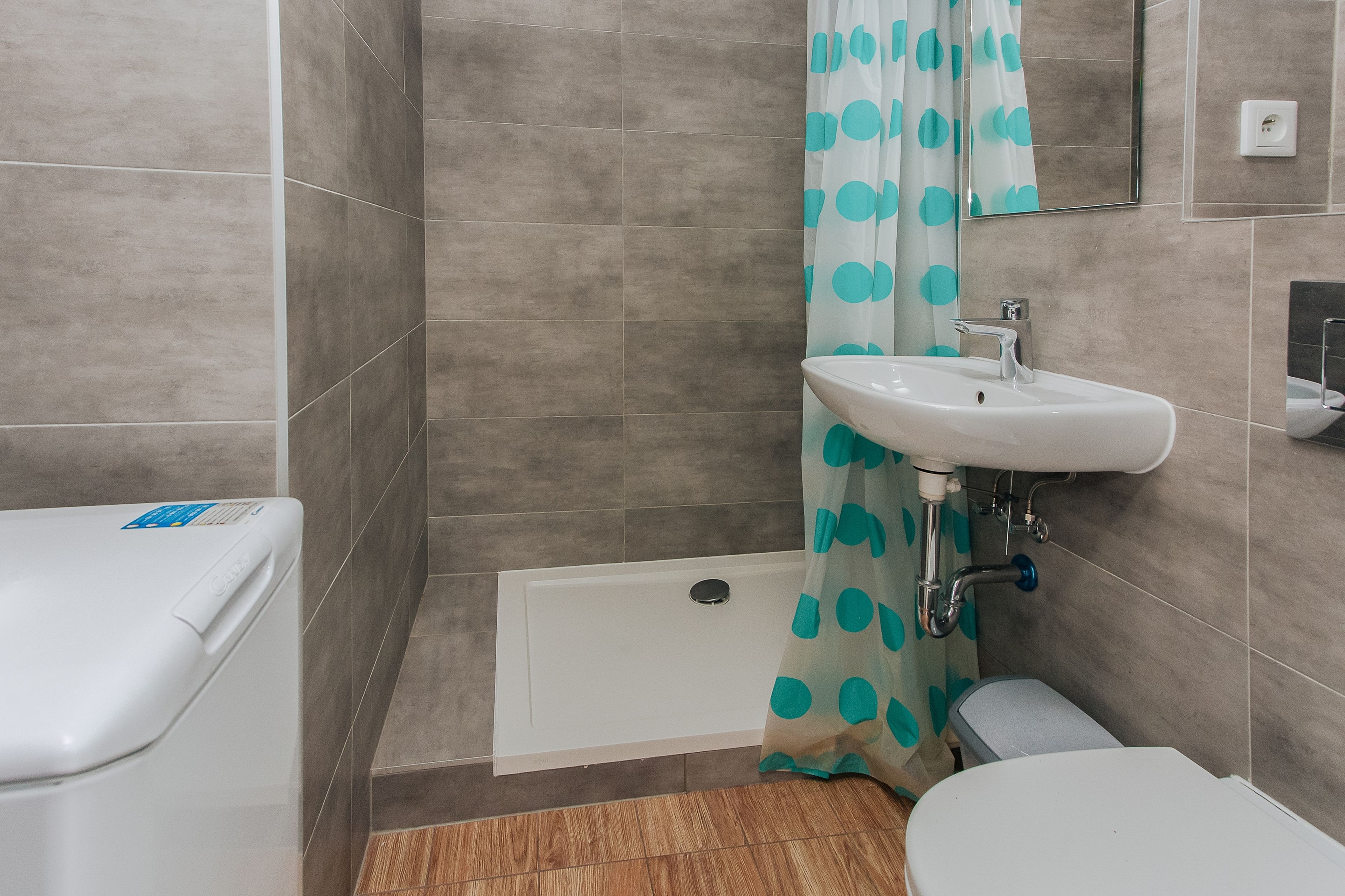 Een badkamer met toilet, wastafel, douche en bad.