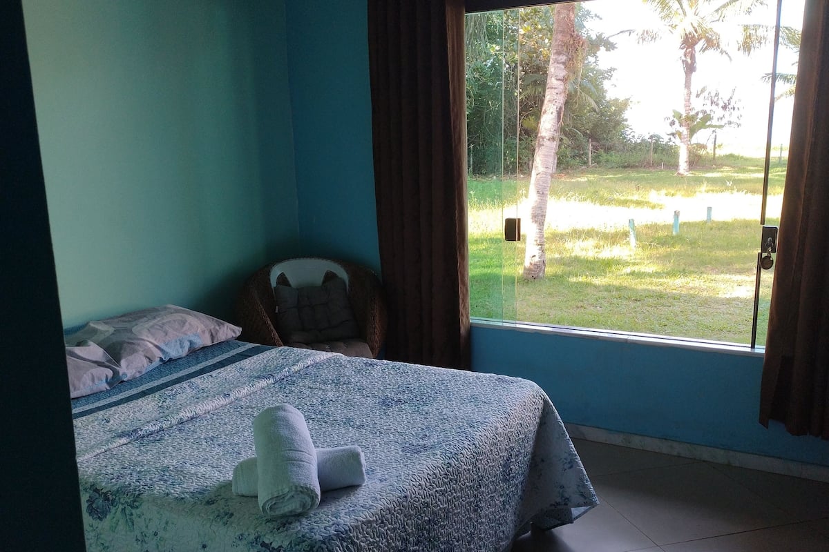 A bedroom with a bed, a window, and a ceiling fan.