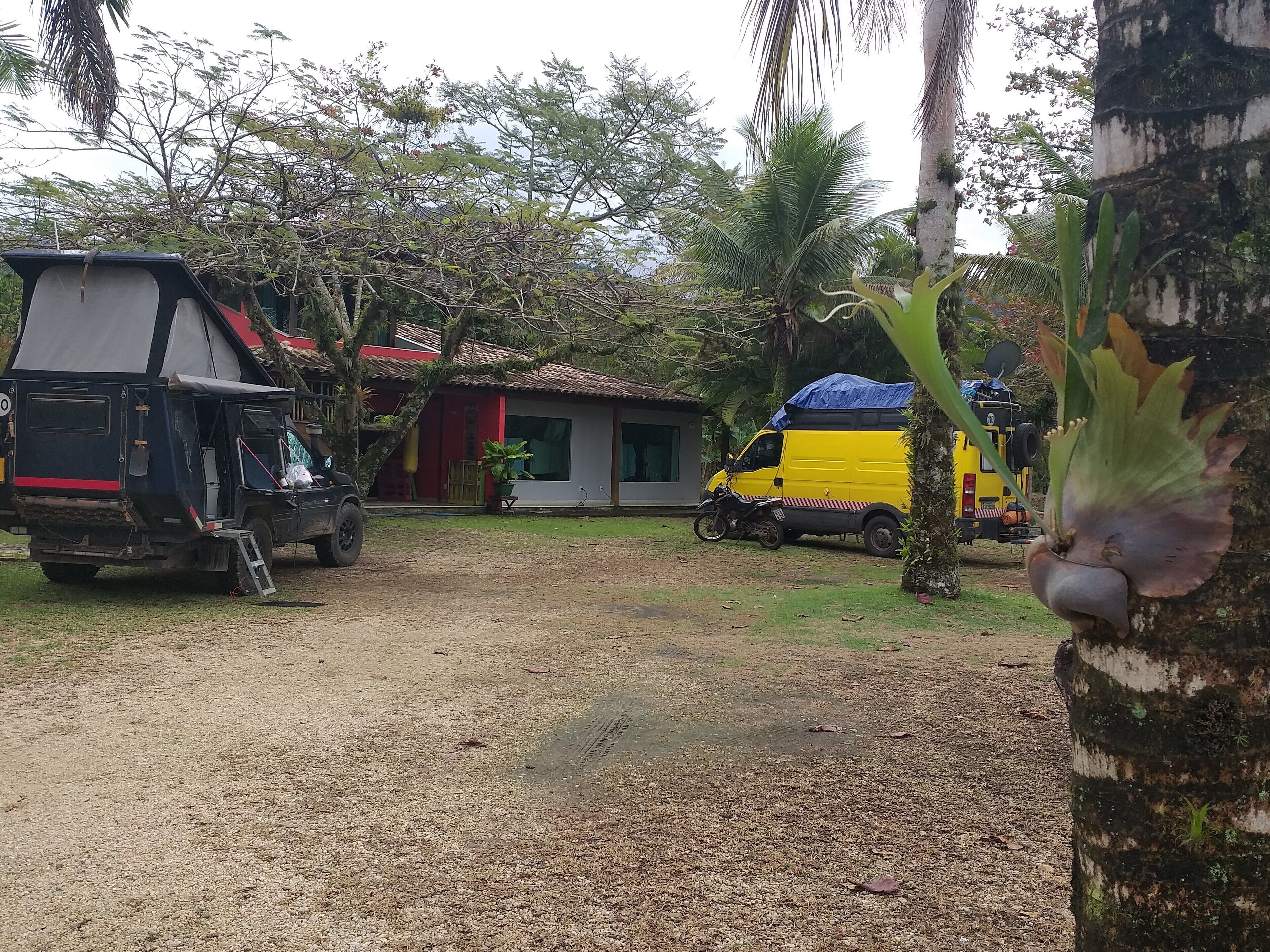 A vehicle parked in a driveway with a house in the background.