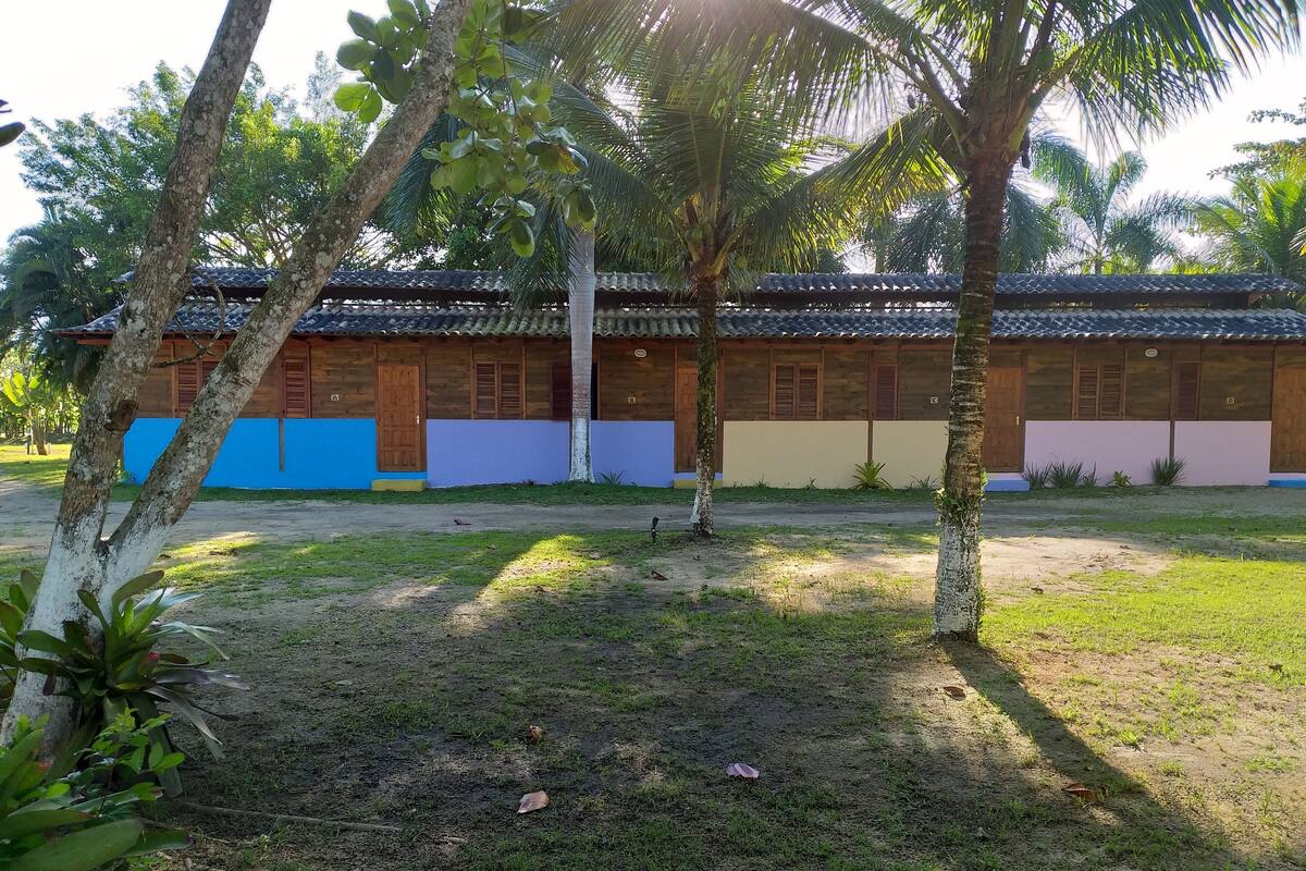 A building with a tiled roof, wooden walls, and a grassy courtyard.