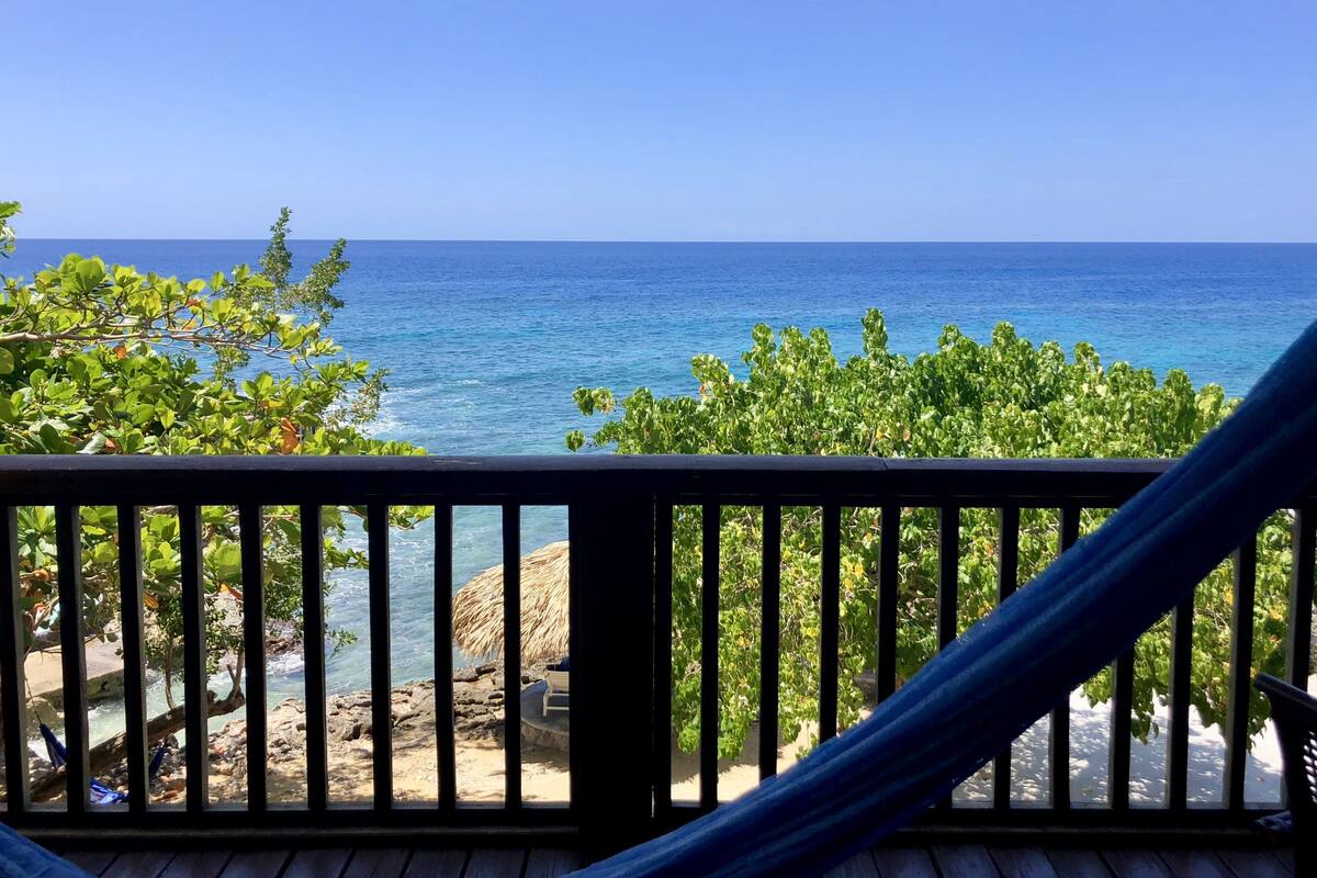 A wooden deck with a view of the ocean.