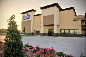 Edificio de Days Inn & Suites con diseño moderno, que cuenta con una entrada amplia y un estacionamiento.