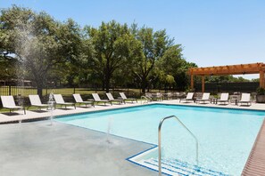 A swimming pool with lounge chairs and a pergola. - Embassy Suites by Hilton San Antonio Brooks Hotel & Spa (San Antonio)