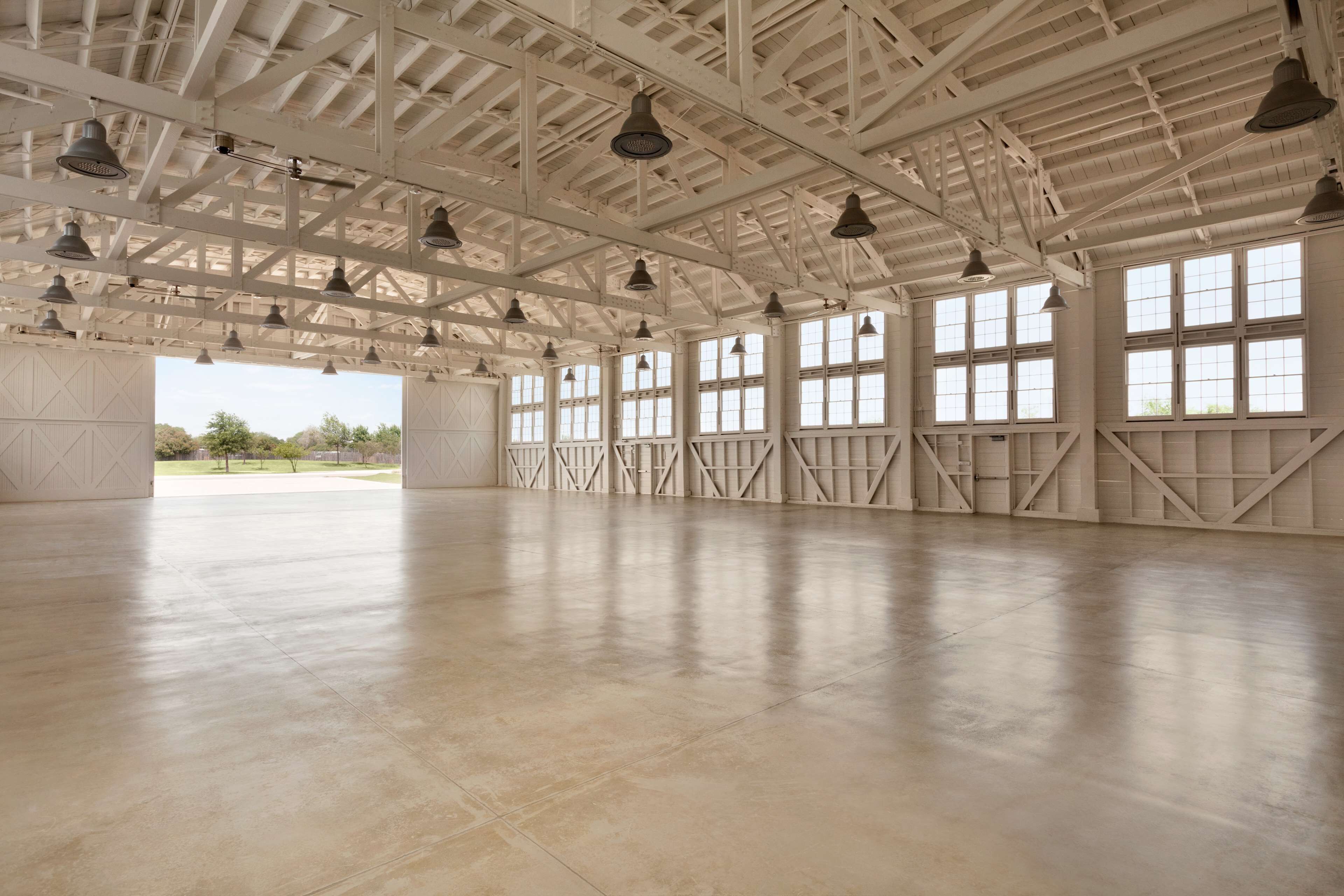 A spacious, high-ceilinged hall with large windows and hanging lights.