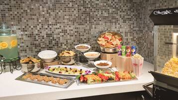 A buffet table with various food items and drinks.