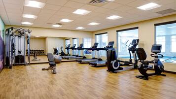 A gym with multiple treadmills, stationary bikes, and weight machines.