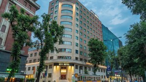 Un hotel de varios pisos con una entrada destacada y un letrero que dice "NYX HOTEL".