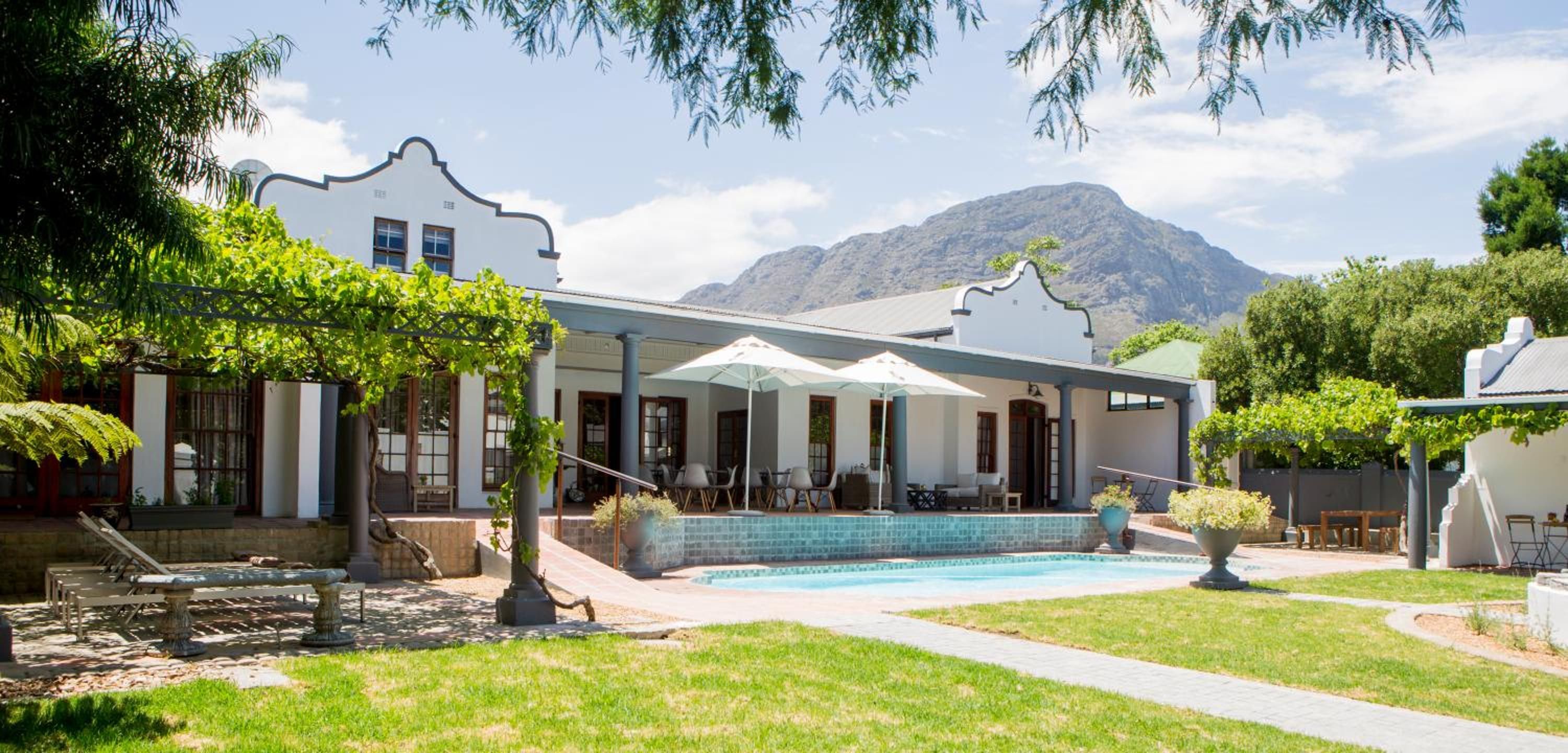 A poolside area with outdoor seating and a mountain backdrop.